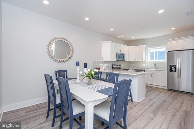 dining space featuring sink and light hardwood / wood-style floors