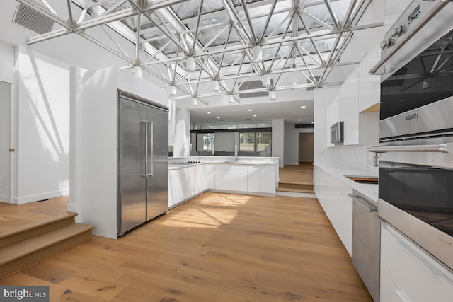 kitchen featuring visible vents, modern cabinets, appliances with stainless steel finishes, and white cabinets