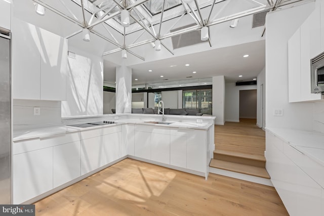 kitchen with modern cabinets, a sink, and white cabinets