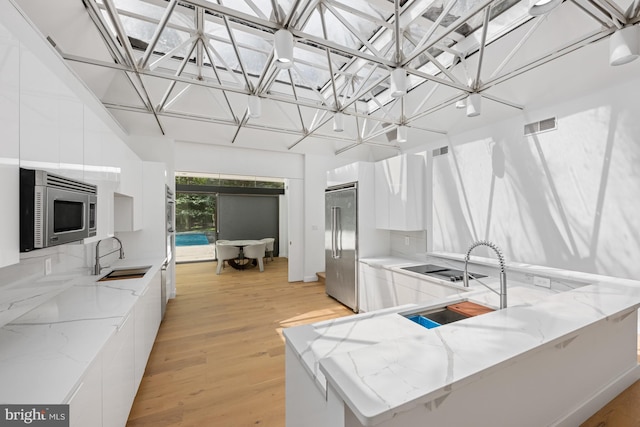 kitchen featuring appliances with stainless steel finishes, modern cabinets, a sink, and white cabinetry