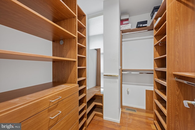 walk in closet with light wood finished floors and visible vents