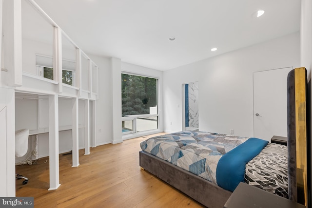 bedroom with baseboards, wood finished floors, and recessed lighting