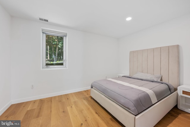 bedroom with light wood-type flooring, baseboards, visible vents, and recessed lighting