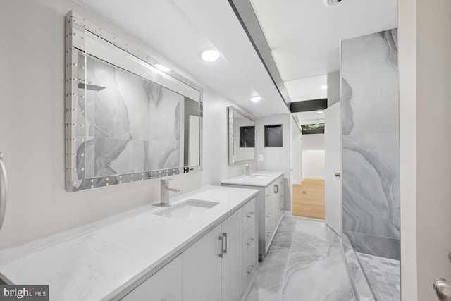 bathroom featuring recessed lighting, marble finish floor, two vanities, and a sink