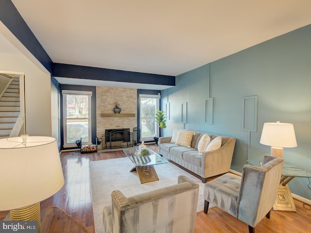 living room featuring light hardwood / wood-style floors and a stone fireplace