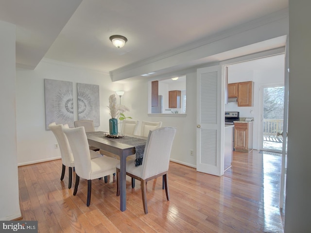 dining space with light hardwood / wood-style flooring and ornamental molding