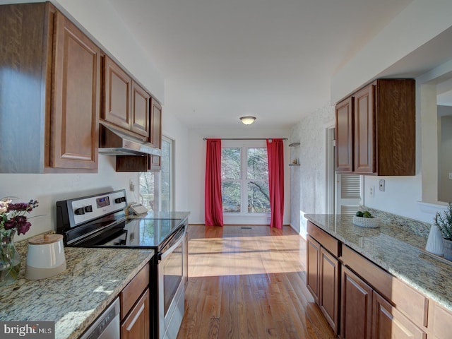 kitchen featuring light stone countertops, stainless steel appliances, and light hardwood / wood-style floors