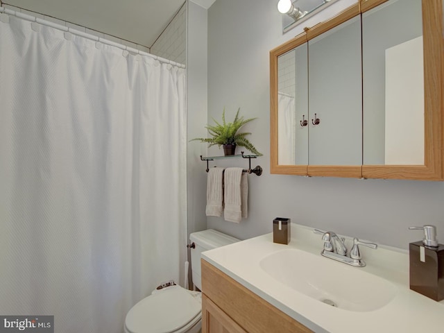 bathroom featuring vanity, curtained shower, and toilet