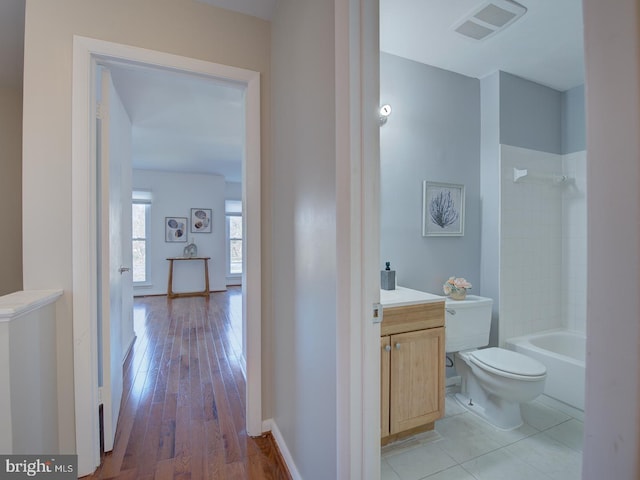 full bathroom with hardwood / wood-style flooring, vanity, toilet, and tiled shower / bath combo