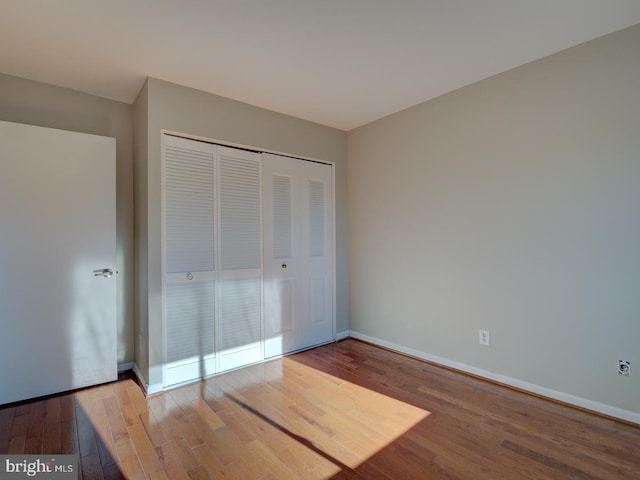 unfurnished bedroom featuring hardwood / wood-style floors and a closet