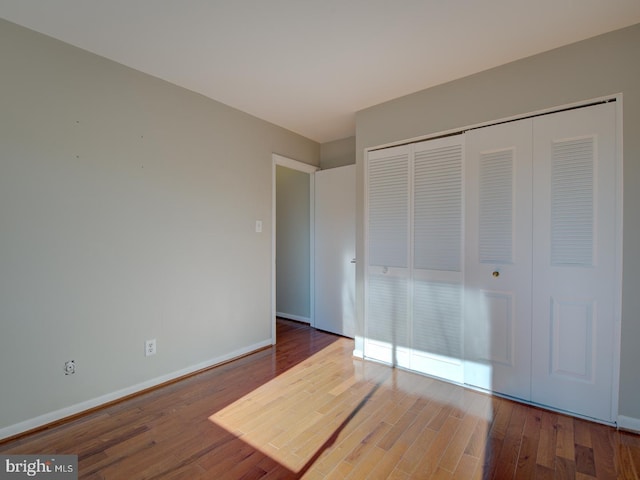 unfurnished bedroom featuring hardwood / wood-style flooring and a closet