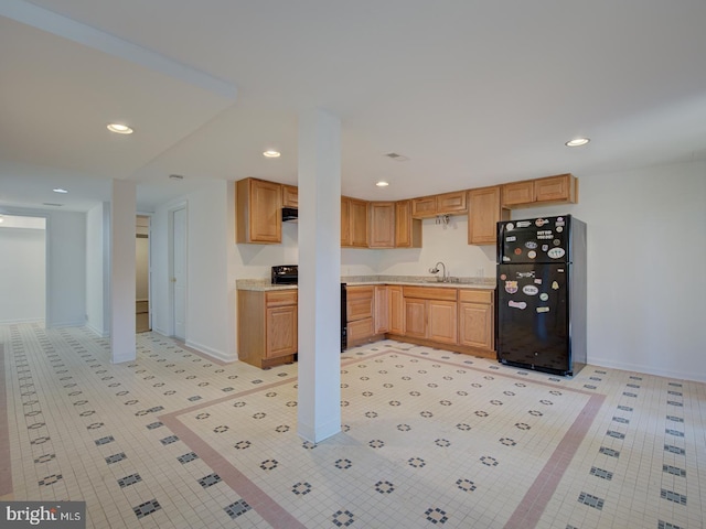 kitchen featuring black fridge, sink, and light brown cabinetry