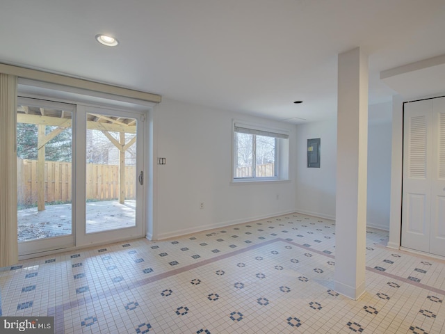 interior space with light tile patterned floors and electric panel