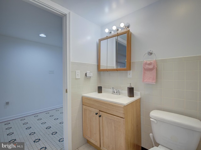 bathroom featuring tile patterned flooring, vanity, tile walls, and toilet