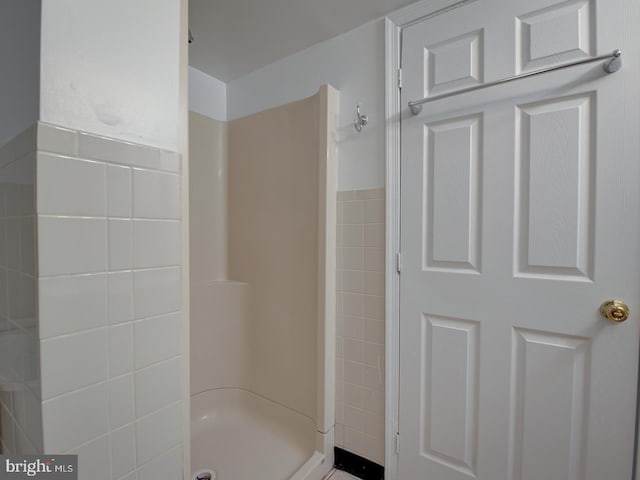 bathroom featuring a shower and tile walls