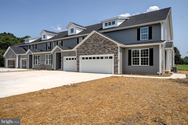 view of front facade with a garage and central AC