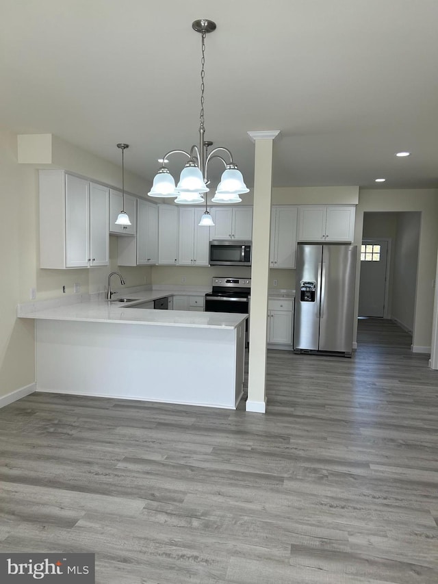 kitchen featuring white cabinets, appliances with stainless steel finishes, light wood-type flooring, and sink