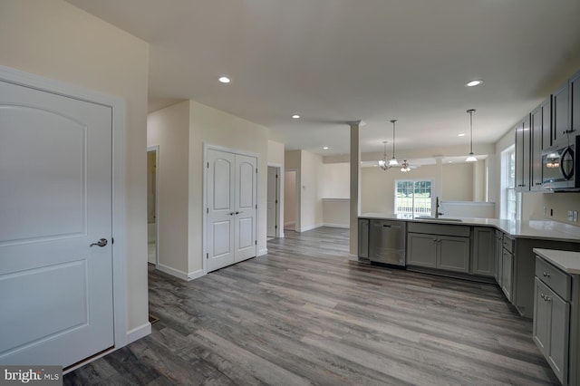 kitchen featuring sink, gray cabinets, appliances with stainless steel finishes, decorative light fixtures, and wood-type flooring