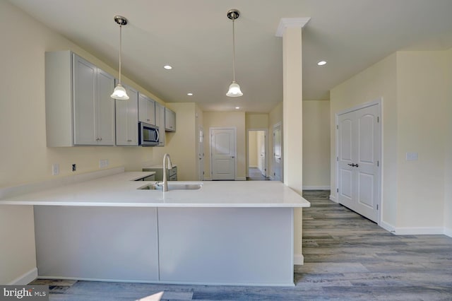 kitchen featuring kitchen peninsula, light wood-type flooring, gray cabinetry, and sink