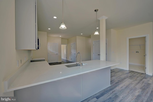 kitchen featuring kitchen peninsula, sink, and decorative light fixtures