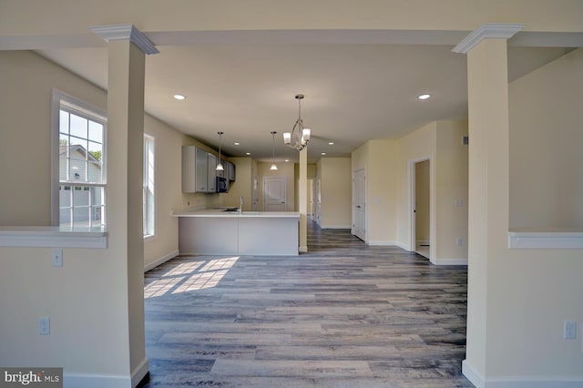 kitchen with hardwood / wood-style floors, sink, gray cabinets, kitchen peninsula, and a chandelier