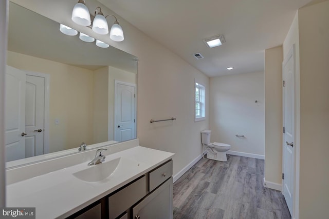 bathroom with hardwood / wood-style floors, vanity, and toilet