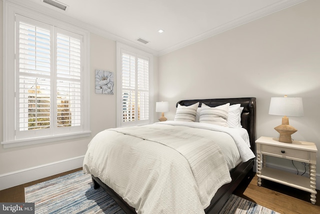 bedroom with crown molding and hardwood / wood-style floors