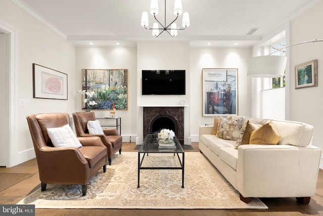 living room featuring light hardwood / wood-style floors, a premium fireplace, ornamental molding, and a chandelier