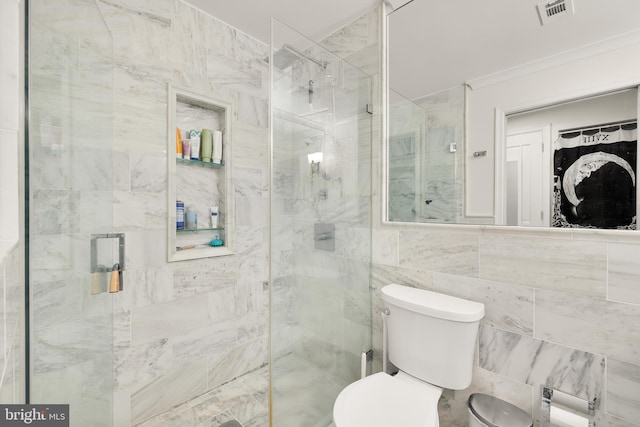 bathroom featuring crown molding, toilet, walk in shower, and tile walls