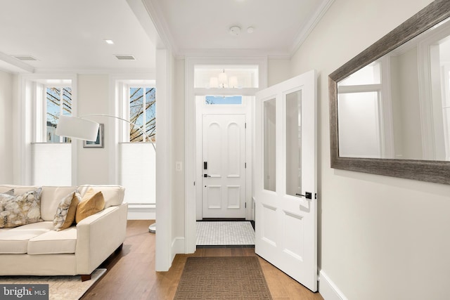 entryway featuring wood-type flooring and ornamental molding