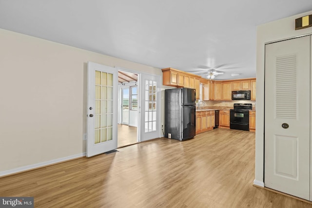 kitchen featuring french doors, black appliances, light hardwood / wood-style floors, ceiling fan, and sink