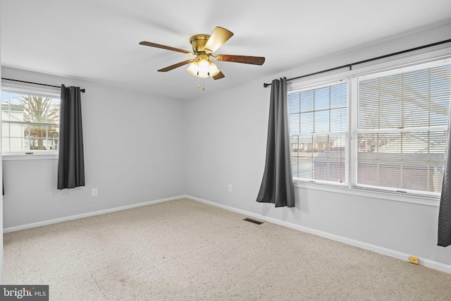 spare room with carpet flooring, ceiling fan, and a healthy amount of sunlight