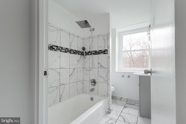 bathroom featuring toilet and tiled shower / bath