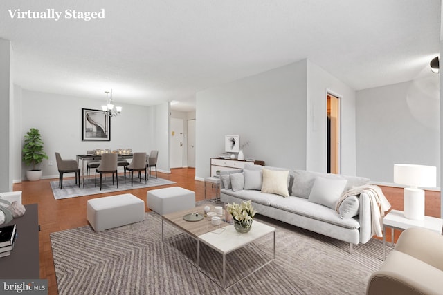 living room with a chandelier, a textured ceiling, and hardwood / wood-style flooring