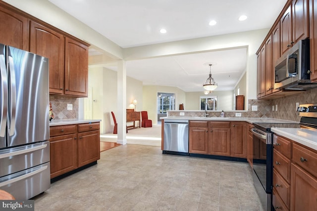 kitchen with backsplash, decorative light fixtures, kitchen peninsula, and stainless steel appliances