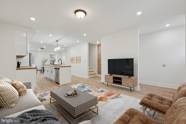 living room featuring a notable chandelier and light wood-type flooring