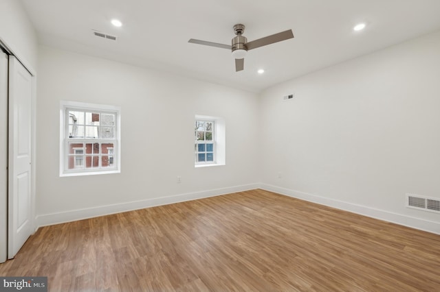 unfurnished room with hardwood / wood-style floors, ceiling fan, and a healthy amount of sunlight