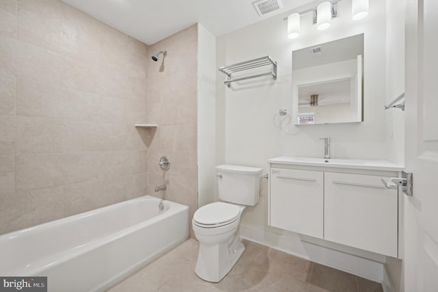 full bathroom with vanity, tiled shower / bath combo, tile patterned floors, and toilet