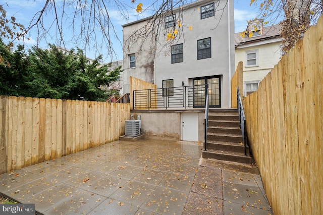 rear view of house featuring cooling unit and a patio area