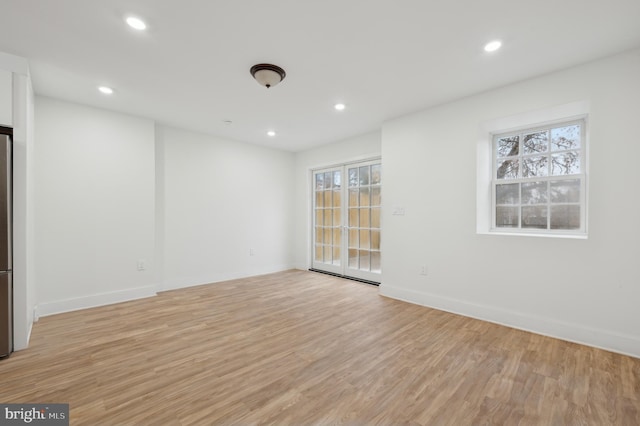 spare room featuring a wealth of natural light and light hardwood / wood-style flooring