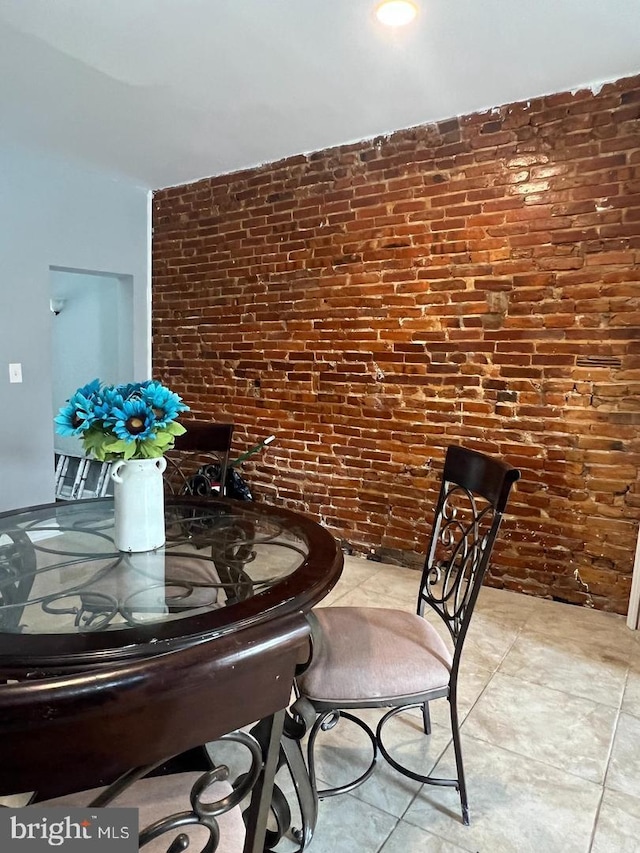 dining room featuring brick wall