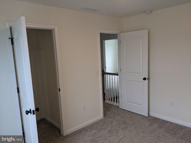 unfurnished bedroom featuring light carpet and a closet