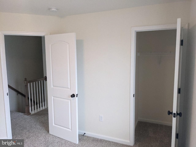 unfurnished bedroom with light colored carpet and a closet