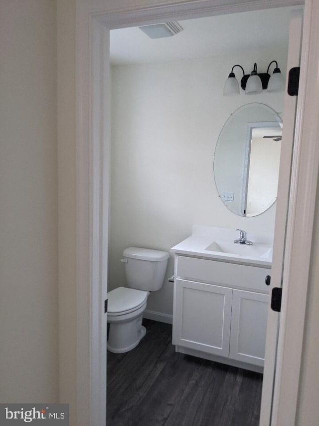 bathroom with hardwood / wood-style floors, vanity, and toilet