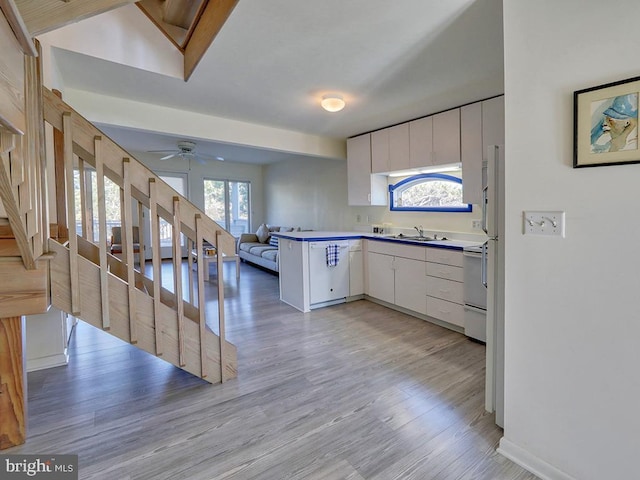 kitchen with white cabinets, ceiling fan, light hardwood / wood-style floors, and sink