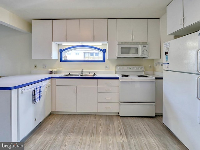 kitchen with white appliances, white cabinets, light wood-style flooring, light countertops, and a sink