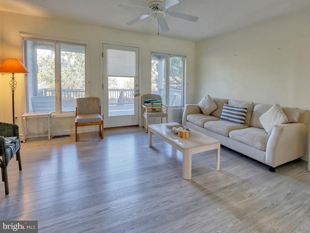 living room featuring wood-type flooring and ceiling fan