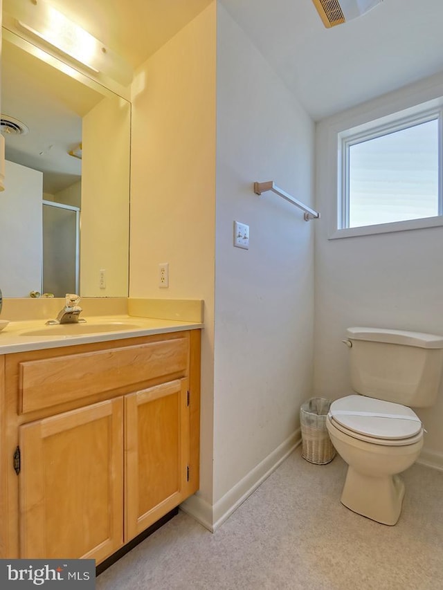 bathroom with vanity, a shower with shower door, and toilet