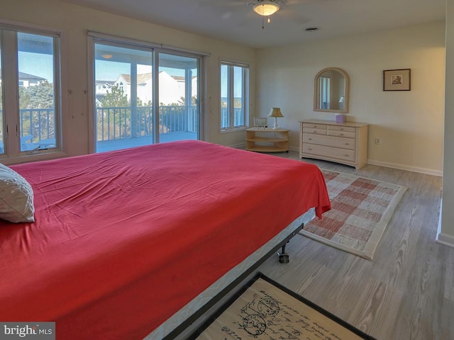 bedroom featuring access to outside, wood finished floors, and baseboards