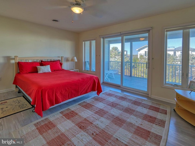 bedroom with access to exterior, baseboards, visible vents, and wood finished floors